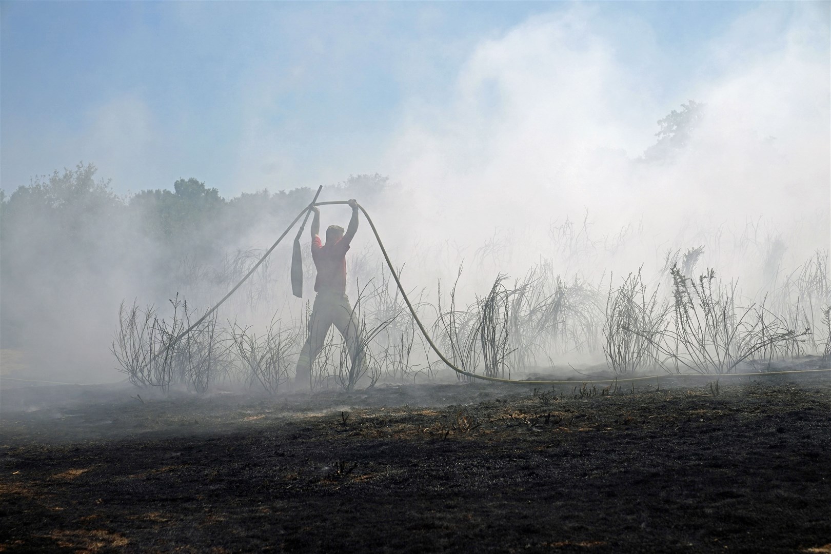 Firefighters battle a grass fire (Yui Mok/PA).