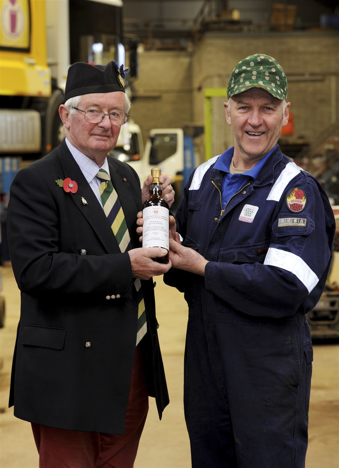 Lord Lieutenant Grenville Johnston [left] presents Gordon Masson with a bottle of whisky for his repairs to the vandalised World War One "Tommy" figure.