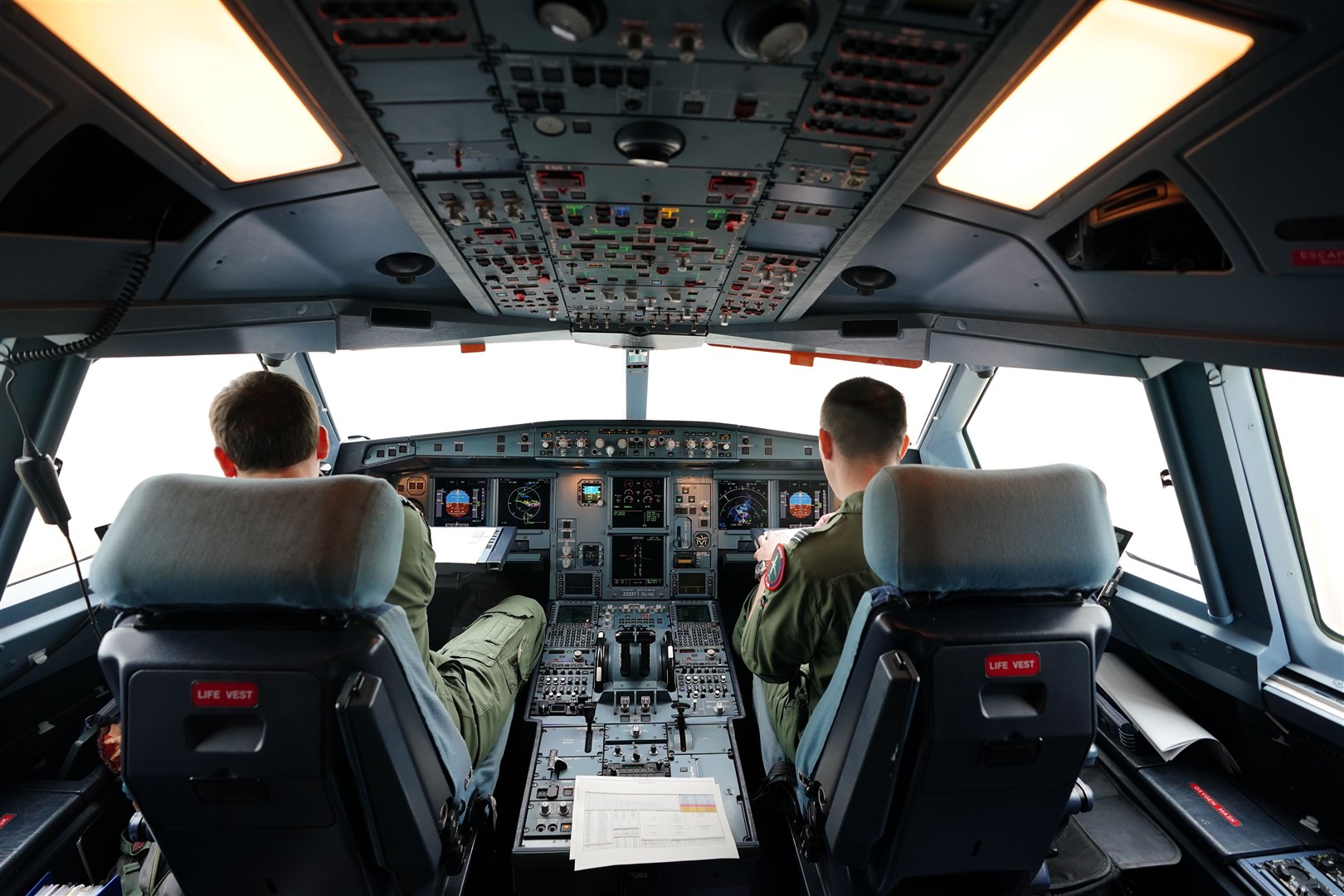 Crew members in the cockpit of a Royal Air Force Voyager (Zac Goodwin/PA)