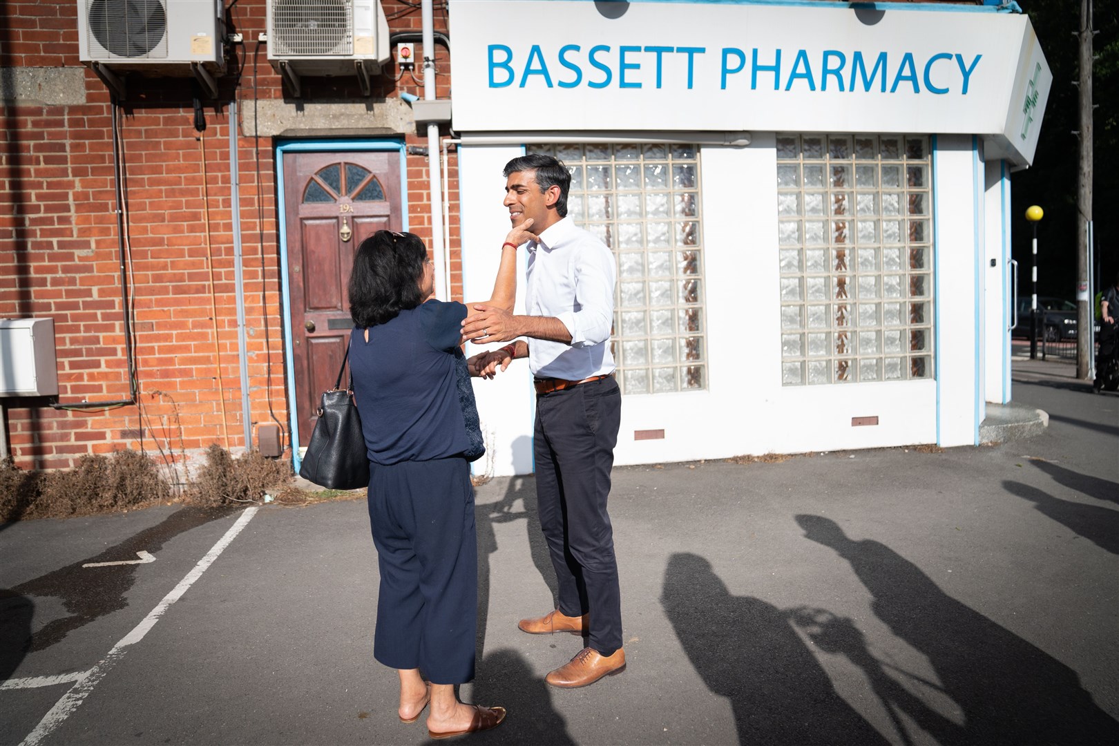 Rishi Sunak bumps into an old family friend during a visit to Bassett Pharmacy, in Southamptpn (Stefan Rousseau/PA)