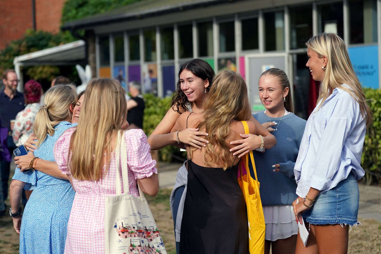Jemima Miller, centre, hugging a person after reading their A-level results at Norwich School (Joe Giddens/PA)
