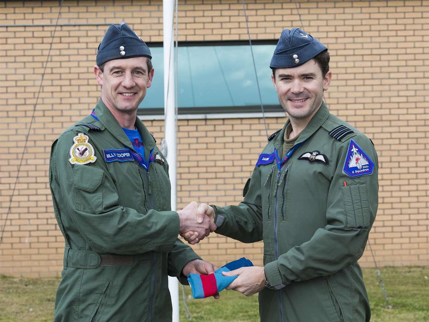 Wing Commander Billy Cooper (left) hands over the 6 Squadron standard to Wing Commander Matthew D’Aubyn who takes command of the the squadron at RAF Lossiemouth.