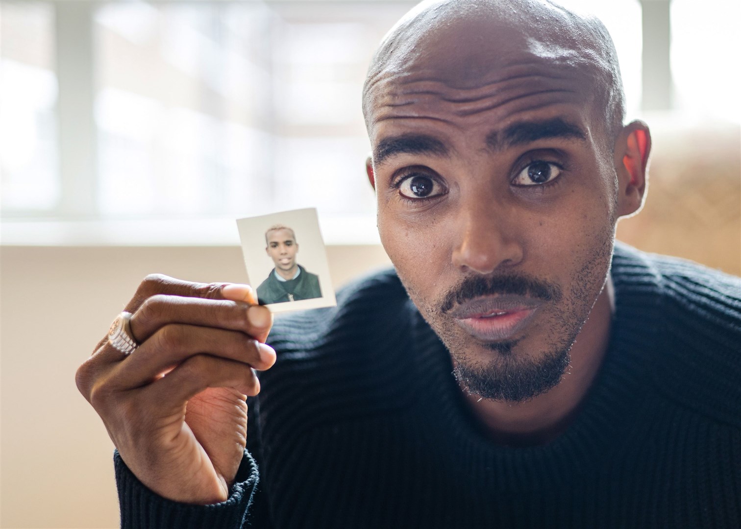 Sir Mo Farah holding up a picture of himself as a child (Andy Boag/BBC/PA)