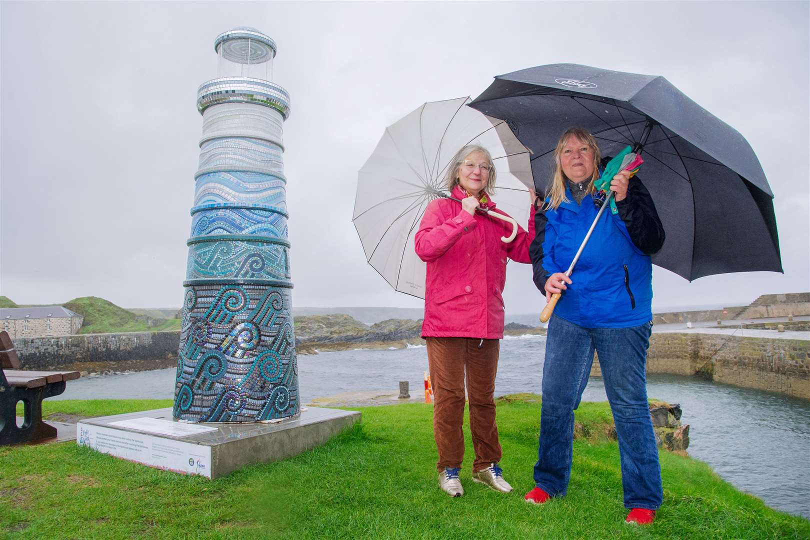 Maria Guerreiro and Paulina Honig brace the rain yesterday to help launch the community campaign to buy the charity lighthouse. Picture: Daniel Forsyth