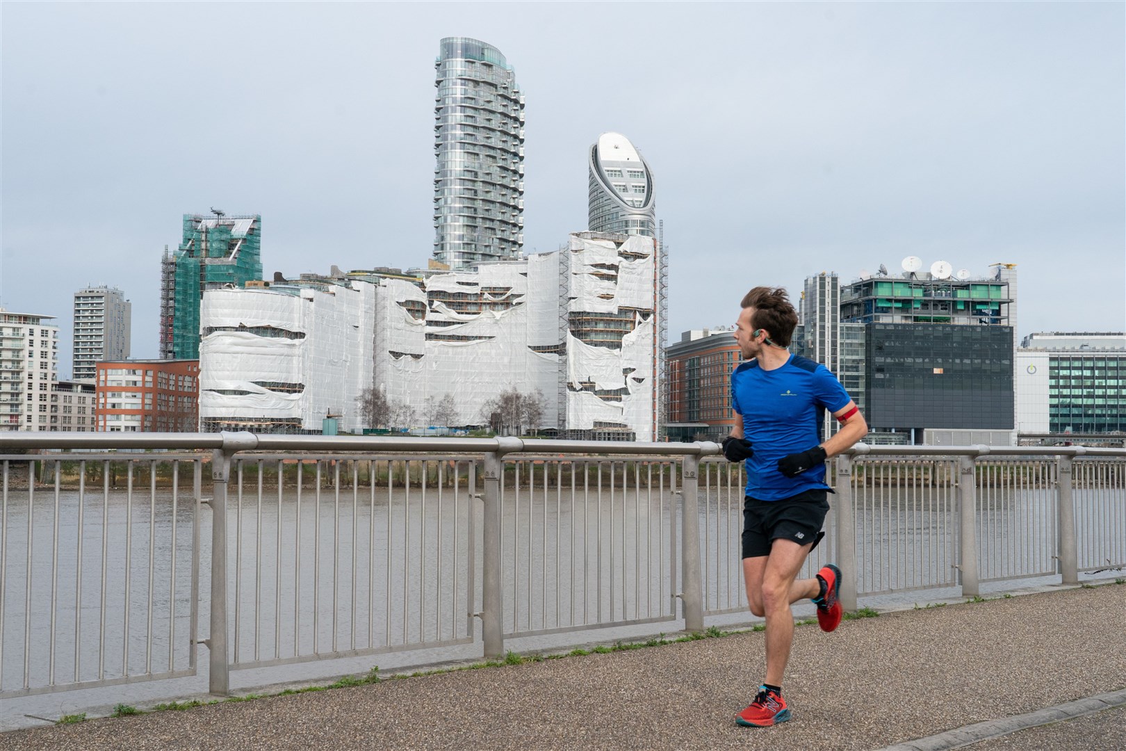 A runner looks at wind damage in London as Storm Eunice struck in February (Dominic Lipinski/PA)