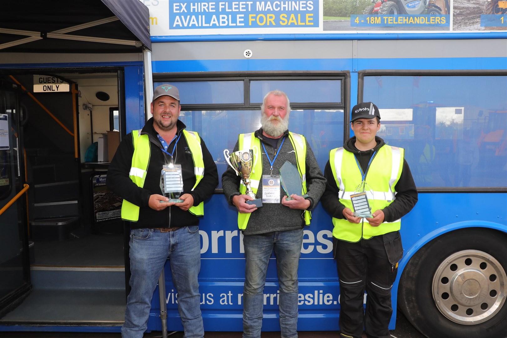 Gordon Durno (centre) proudly shows off his trophy, flanked by runner-up Scott Hamilton (left) and third placed Jamie Currie. Picture: David Wylie, Earthmovers Magazine