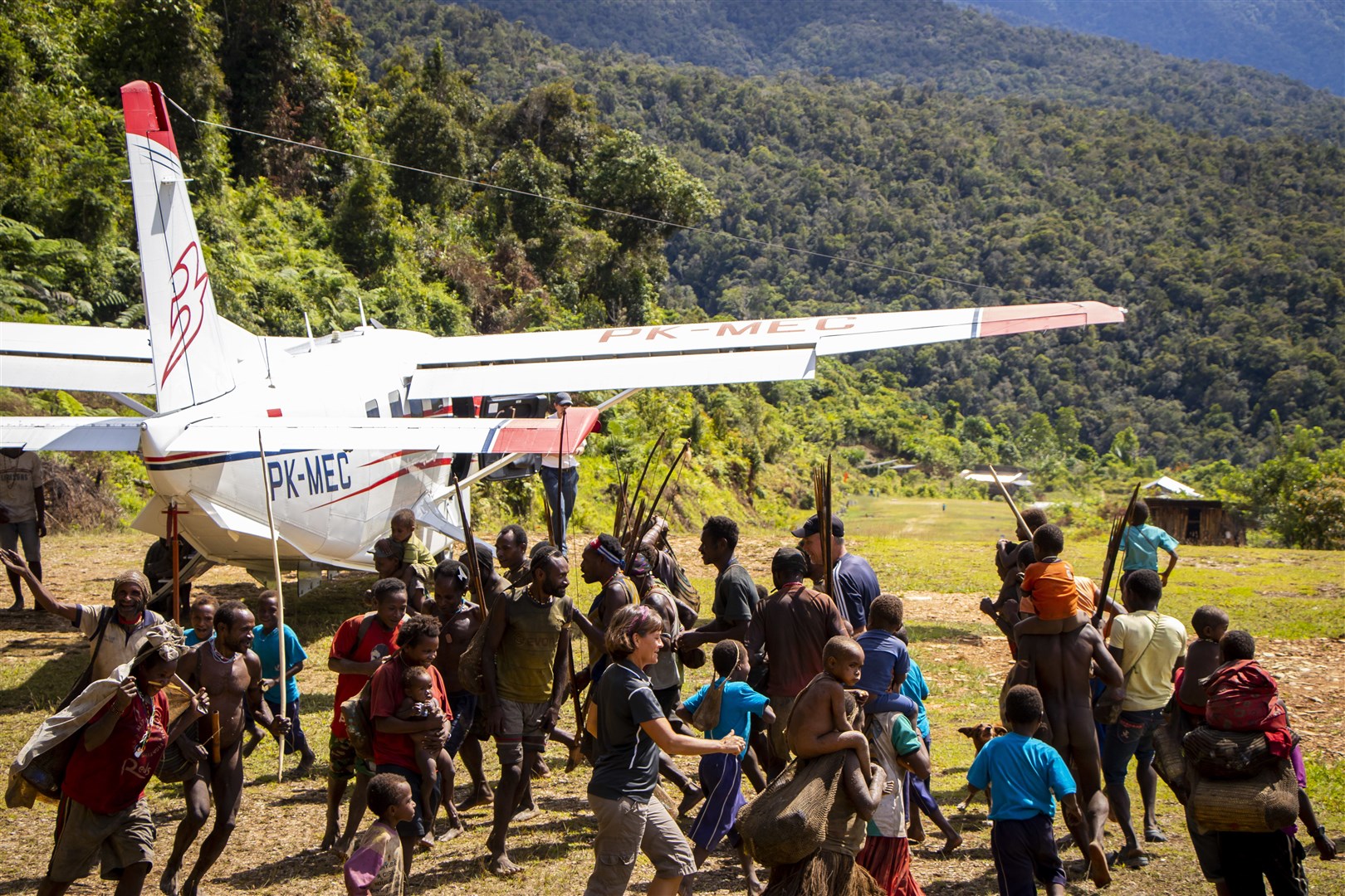 The Moi from Daboto in Papua, Indonesia circle dance on the airstrip along with Bible translators Stephen and Carolyn Crockett