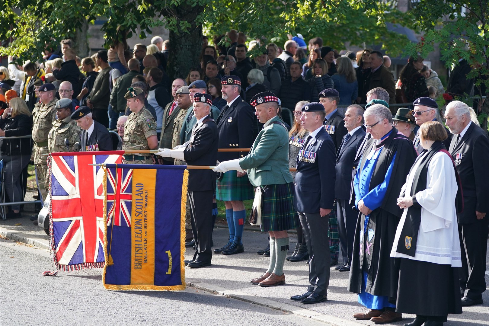 Dignitaries in Ballater watching the hearse carrying the coffin (Andrew Milligan/PA)