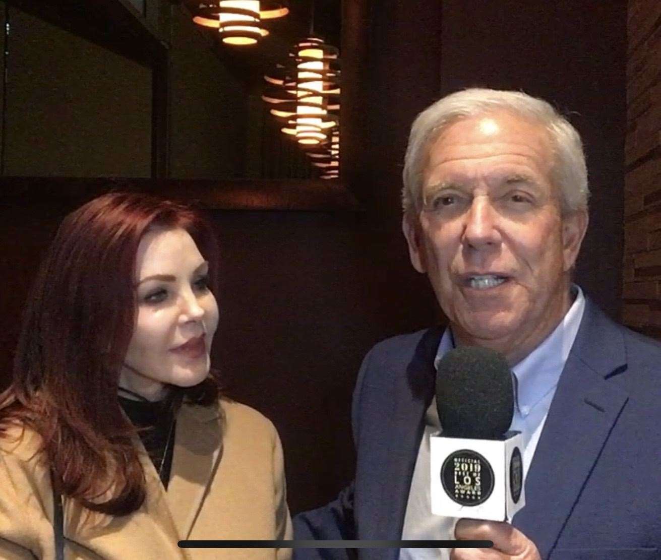 Pat interviewing Priscilla Presley for his show having spent most of his career behind the camera.