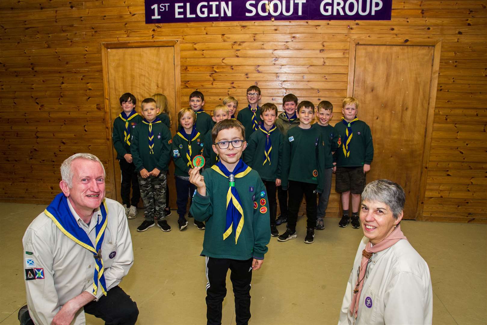 Finlay Dodds is the first cub to earn the Red Squirrel Badge, which was created in Moray. Handing over the badge is leader of 1st Elgin Cub Scouts Kenny McKenna and Mandy McIntosh, assistant district commissioner for Moray District Cubs. Picture: Becky Saunderson.
