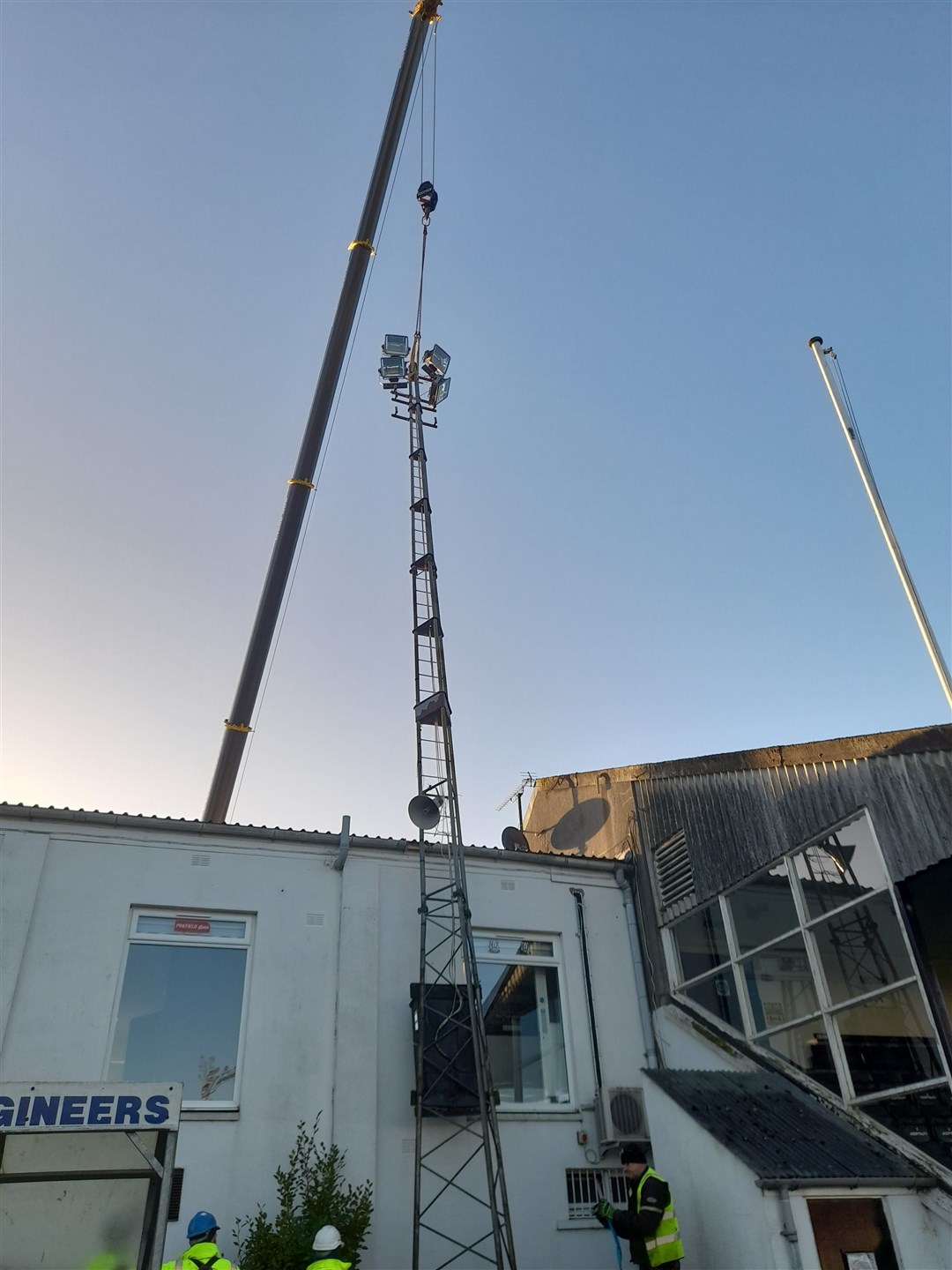 A giant crane winches the floodlight back into place. Picture: Cecil Jack