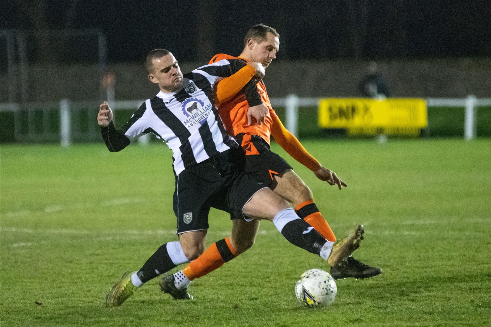 Broch striker Scott Barbour and Rothes' Michael Finnis tussle for the ball. Picture: Daniel Forsyth..