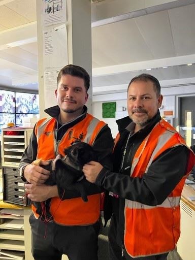 Stefan Hug, left, pictured with driver instructor Kevin Timmins and the rescued puppy (Stefan Hug)