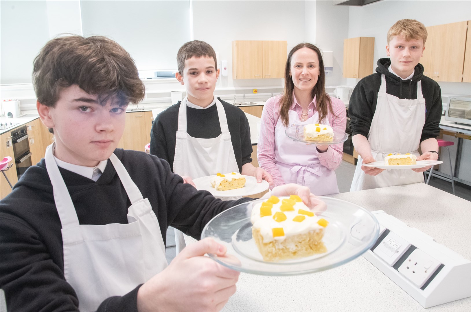 Michael Caton, Hamish Fraser and Cameron Bethell with their 'Made in Moray Mango Three Milk' cake and Katalin Urquhart from Torta. Picture: Daniel Forsyth.