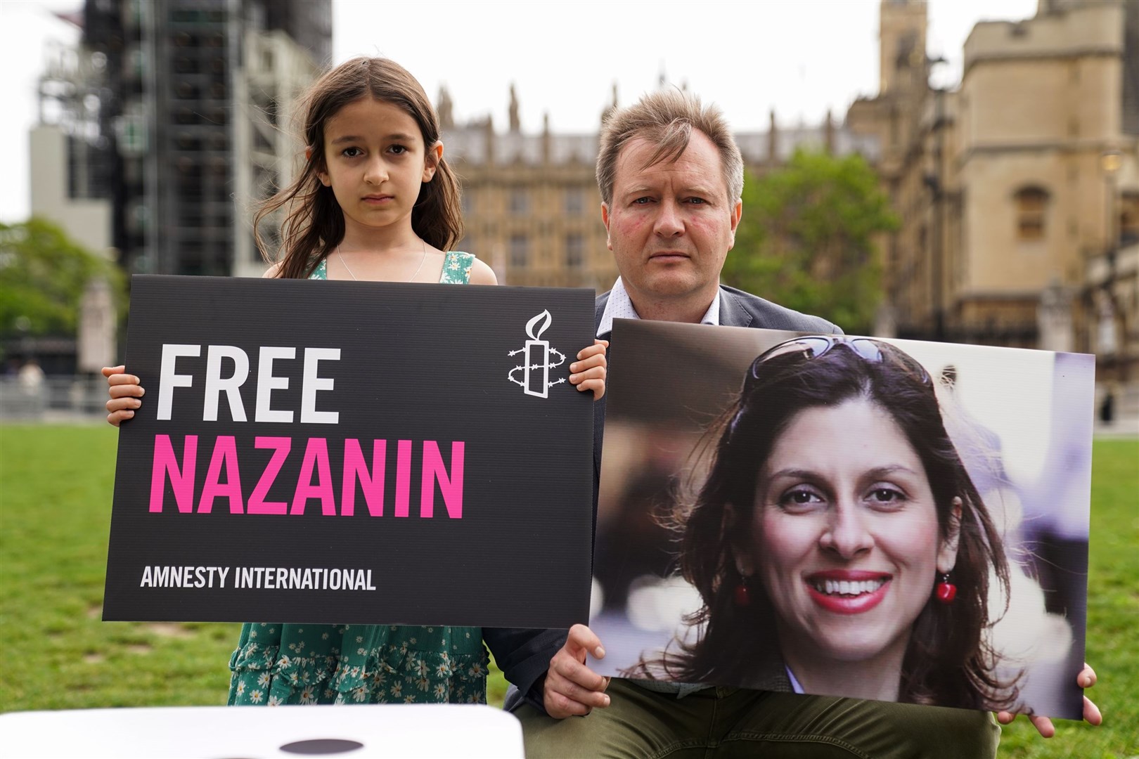 Richard Ratcliffe and his daughter Gabriella hold signs in Parliament Square in September to mark the 2,000th day Nazanin Zaghari-Ratcliffe has been detained in Iran (Kirsty O’Connor/PA)