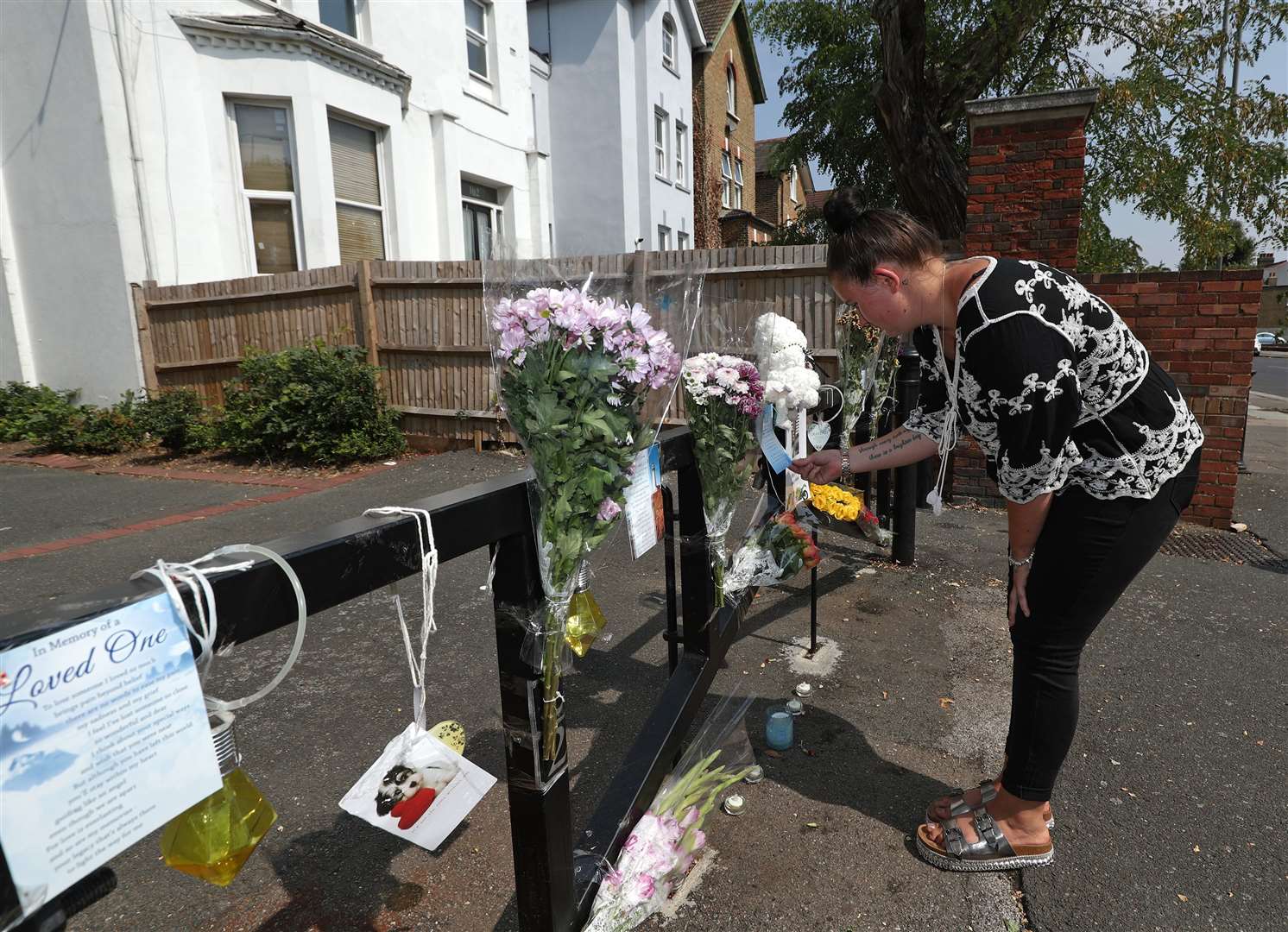 Hollie Edwards, the daughter of Dean Edwards, looks at tributes for her father at Betts Park in south London (Yui Mok/PA)