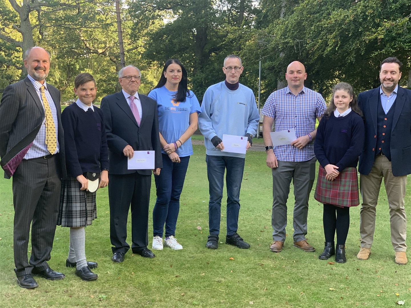 Pupils from Gordonstoun's Junior School present money raised from the Junior Highland Games to representatives of this year's chosen charities.