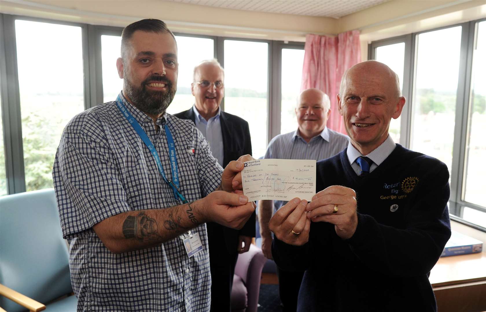 George Duthie (right) presents a cheque to Friends of Dr Gray's Hospital chairman Tim Wakefield, with Rotarian Jim Royan and Dr Ken Brown (back right).