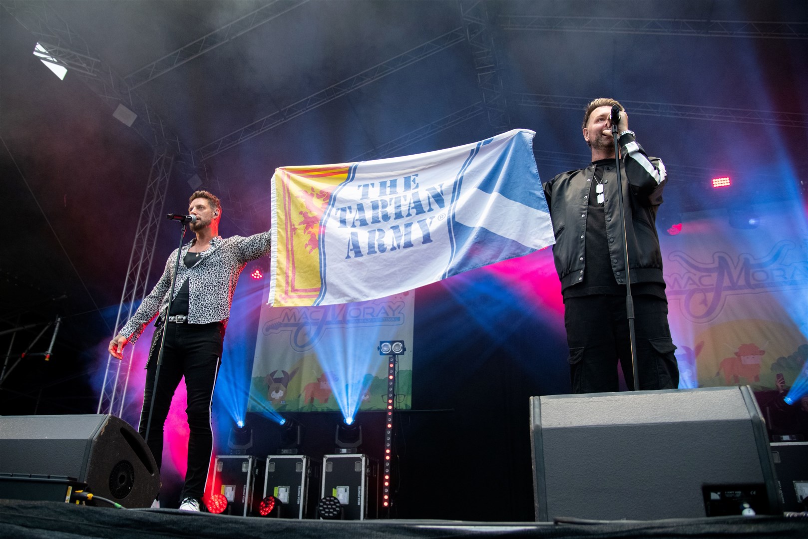 Keith Duffy and Brian McFadden of Boyzlife unveil a Tartan Army flag on the mainstage during their Sunday afternoon set. Picture: Daniel Forsyth.