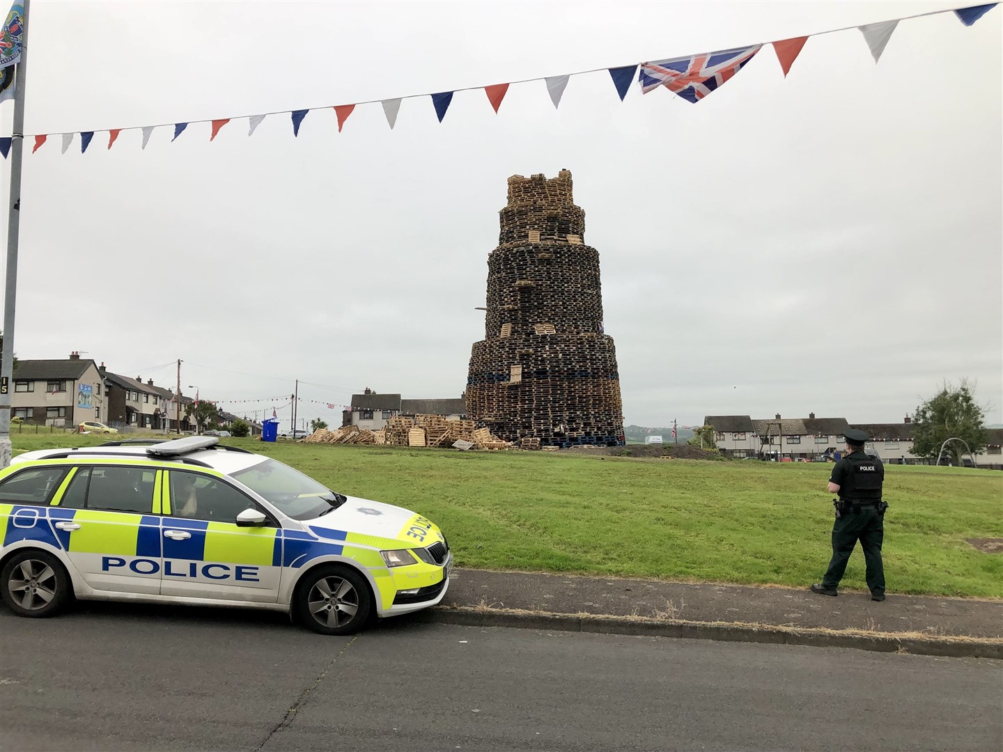 Police remained at the scene on Sunday morning prior to the bonfire being dismantled (PA)