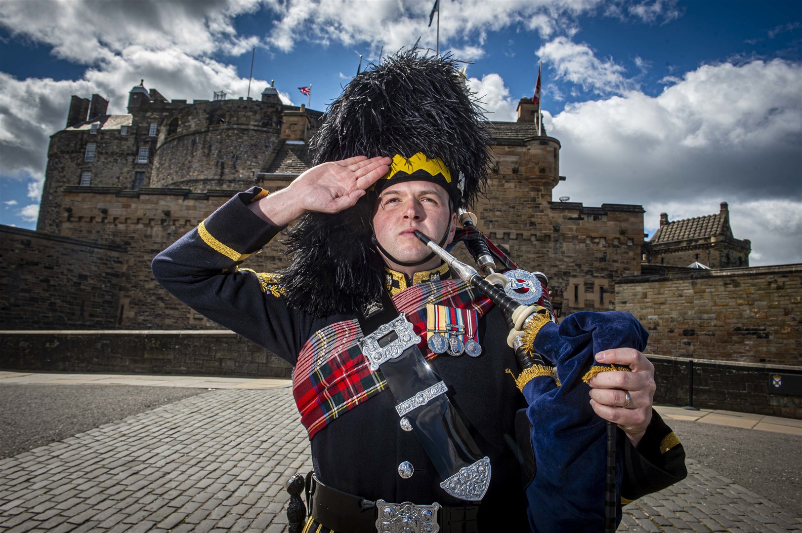 Pipe Major Ben J Duncan, from The Royal Scots Dragoon Guards Pipes and Drums, previews the Heroes of St Valéry from the doorstep of Edinburgh Castle. Photo by Mark Owens/Poppyscotland.