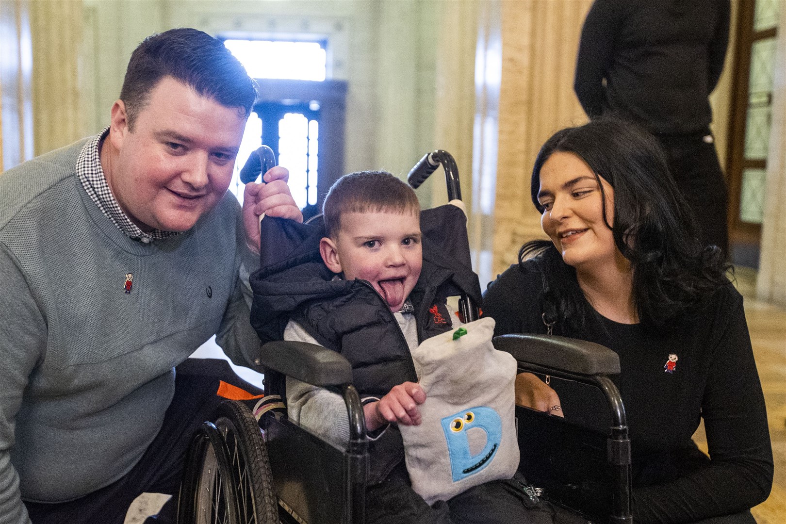 Six-year-old Daithi MacGabhann with his parents Mairtin Mac Gabhann (left) and Seph Ni Mheallain at Parliament Buildings at Stormont (Liam McBurney/PA)