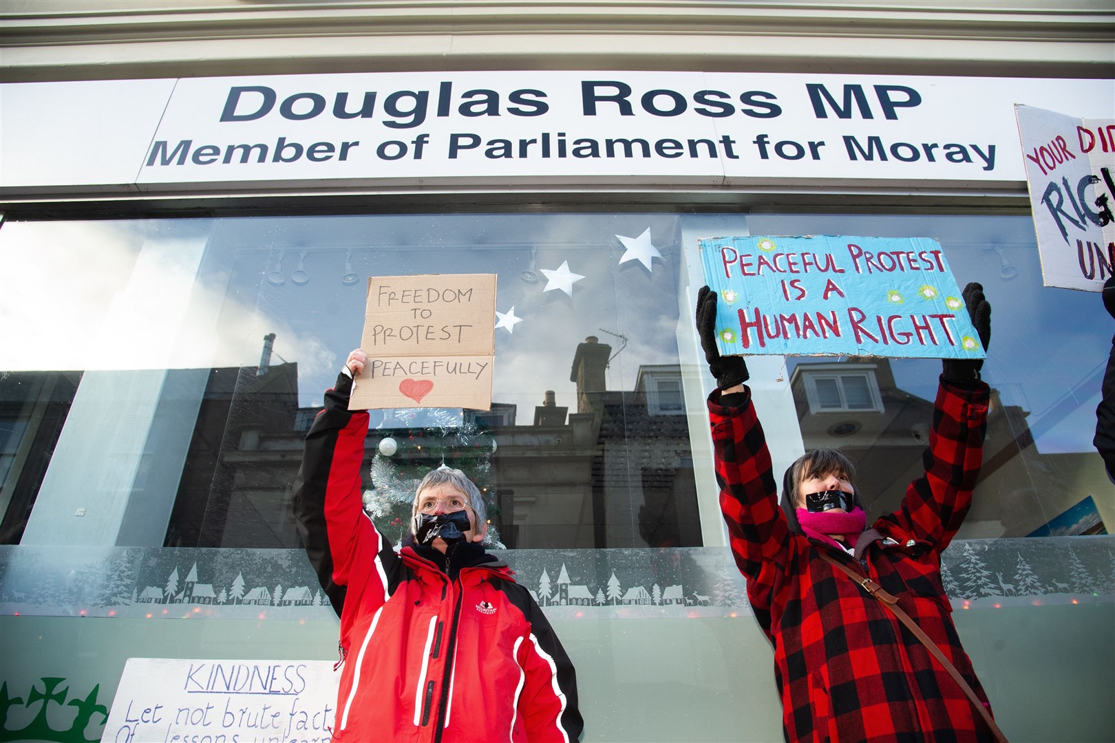 Demonstrators taped up their mouths and held placards outside the office of Moray MP Douglas Ross on December 8. Picture: Daniel Forsyth.