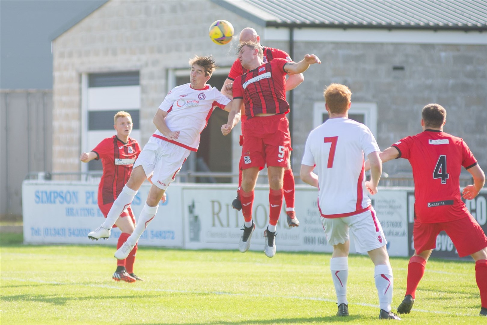 Brora Rangers' Colin Williamson competes against Elgin City defenders Euan Spark and Stephen Bronsky to win a high ball. Picture: Daniel Forsyth..
