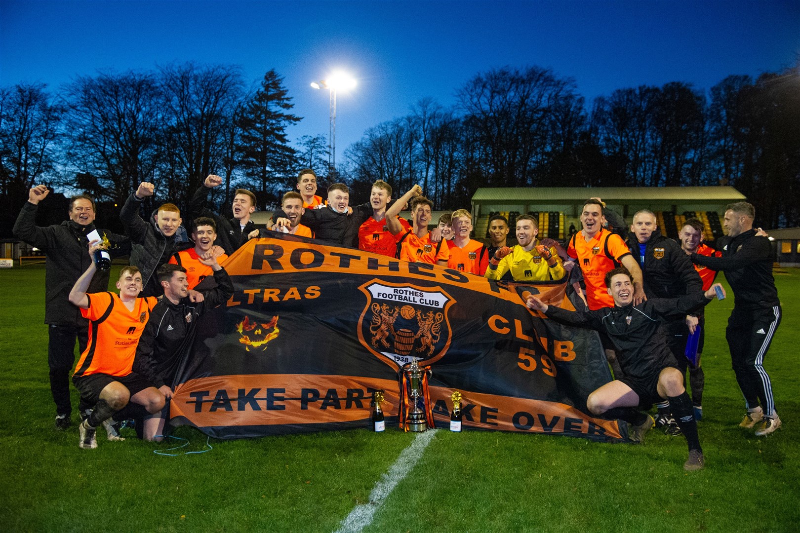 Rothes players celebrate with their fans' ultras banner after full-time. Picture: Daniel Forsyth