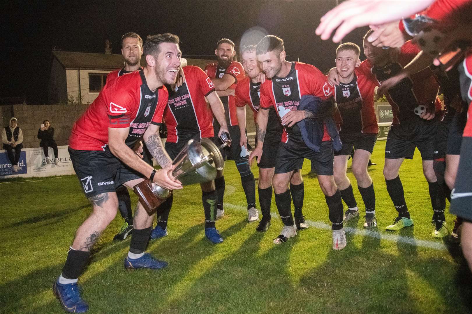 Fochabers skipper Ben Stewart leads the celebrations with the cup. ..Fochabers FC (7) vs Hopeman FC (2) - Mike Simpson Cup Final 2023 - Grant Park, Lossiemouth...Picture: Daniel Forsyth..