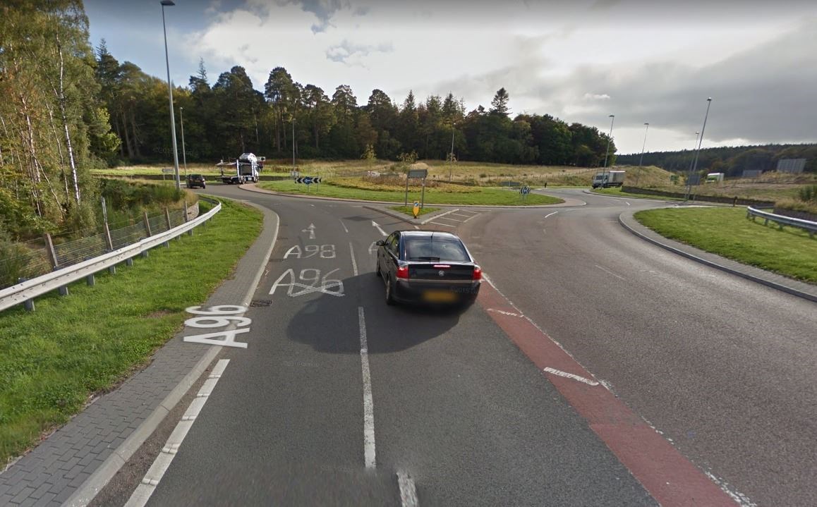The roundabout's approach from the Elgin side. Both lanes can be used to continue on the A96 to Keith, with a left turn for Buckie.