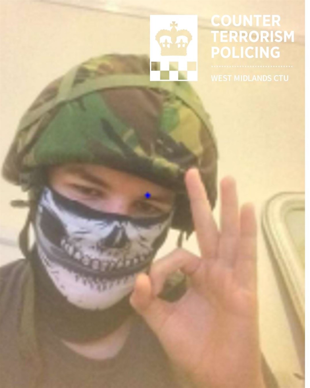 Vaughan Dolphin wearing an army helmet, wearing a skull mask, and making the ‘okay’ hand gesture – which is linked to the white supremacist movement (West Midlands Police/PA)