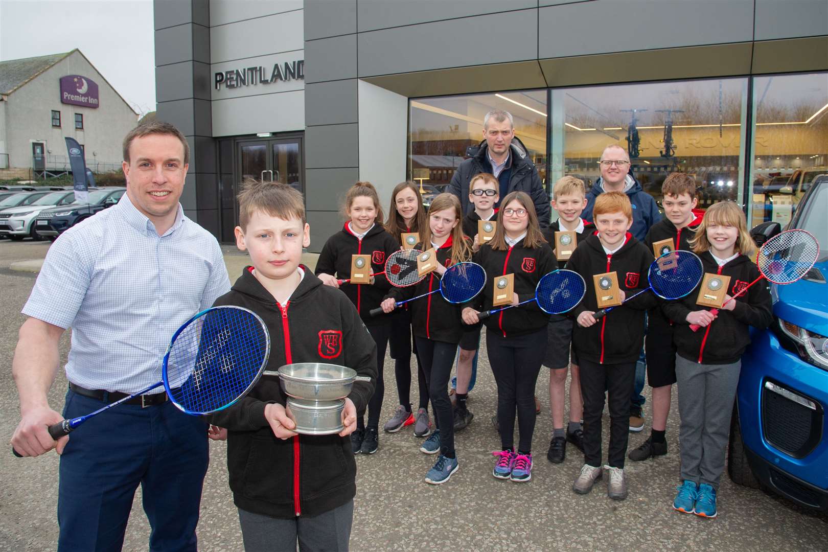 West End Primary School badminton team visit their sponsors Pentland Land Rover in Elgin to show the team the Scottish Schools Badminton Union Primary Quaich, which they have won for the second year in a row. Welcoming the team and their coaches Daniel Mcwhirter and Lloyd Griffiths is Adam Rhind. Picture:Daniel Forsyth.