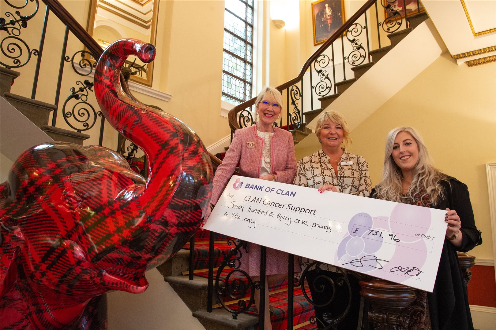 Ann Tribe and Amy Stevenson from Walkers hand over a cheque to Tracy Sellar (centre) from CLAN.