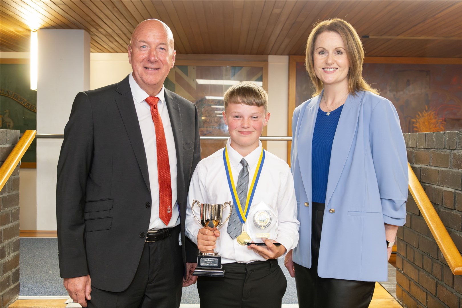 Elgin Boys' Club's juniors' player of the year Finlay Douglas, flanked by Aberdeen legend Neil Simpson and club secretary Margaret Ramage. Picture: Beth Taylor
