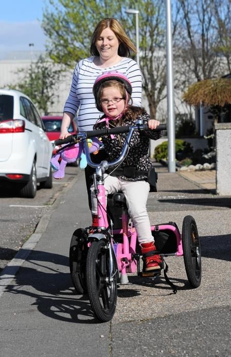 Faye Cruickshank enjoys a ride on her special trike with mum Jodie. Photo by Eric Cormack.