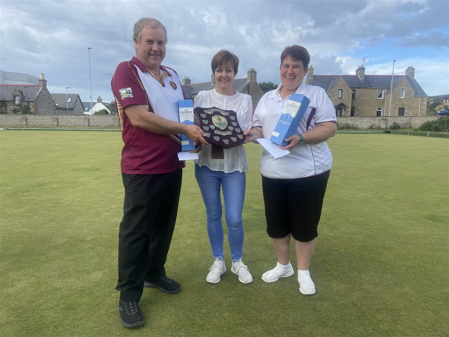Keith Bowling Club pair Davie Bell and Karen Dalgarno receive the Murray Cormie Memorial Pairs Trophy from Audrey Christie at Burghead's St Aethan's Bowling Club.
