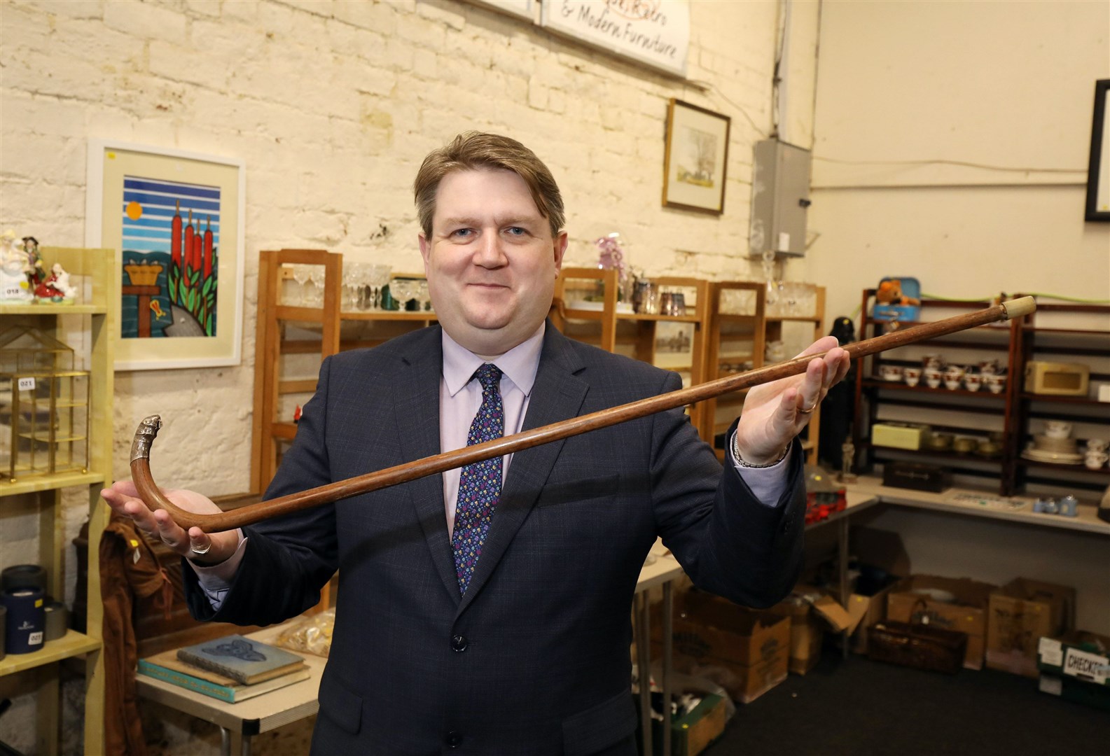 Karl Bennett, managing director of Bloomfield Auctions, holding a walking stick that once belonged to Michael Collins (PA) 
