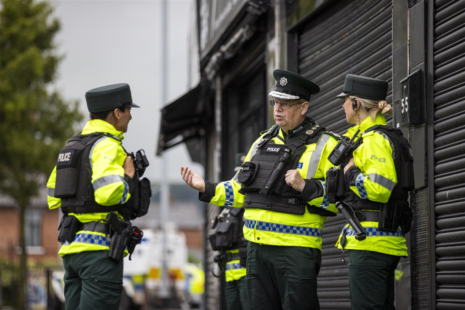 Police Service of Northern Ireland Chief Constable Simon Byrne (second from right) speaking with colleagues during on a walkabout in Belfast in July 2023 (Liam McBurney/PA)
