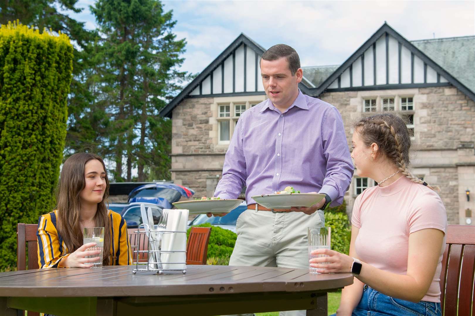 Moray MP Douglas Ross helps the Eat Out to Help Out initiative at Forres' Ramnee Hotel as he serves Hayley Kenna (left) and Heather Anderson (right) their food. Picture: Daniel Forsyth