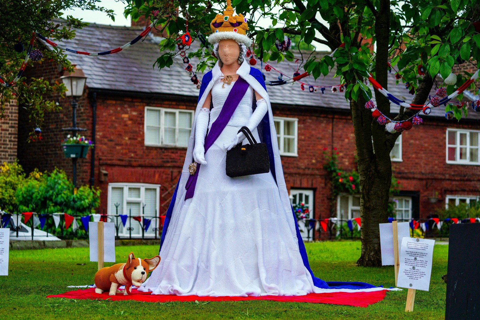 A life size knitted Queen and corgi in the village of Holmes Chapel in Cheshire, ahead of the Platinum Jubilee celebrations (Peter Byrne/PA)