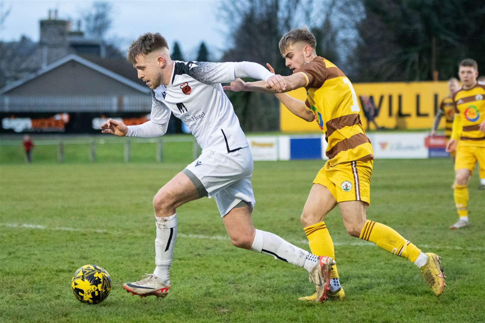Rothes' Jake Thomson plays away from Forres full back Mark McLauchlan...Forres Mechanics FC (0) vs Rothes FC (1) - Highland Football League 23/24 - Mosset Park, Forres 25/11/2023...Picture: Daniel Forsyth..