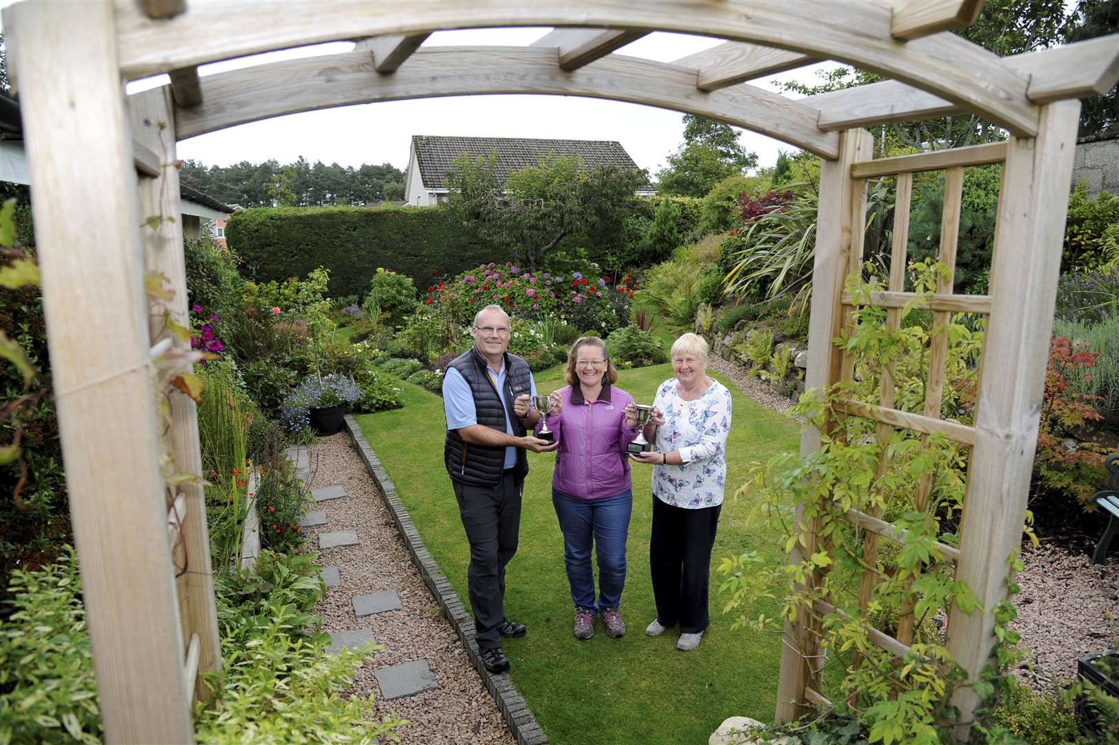 Lhanbryde & District Gardening Club's secretary Gail Mands (centre) presents trophies to the winner of the best kept large garden Graeme Hastie (left) and the winner of the best kept small garden Sheila Gowans. Picture: Eric Cormack. Image No. 044674.