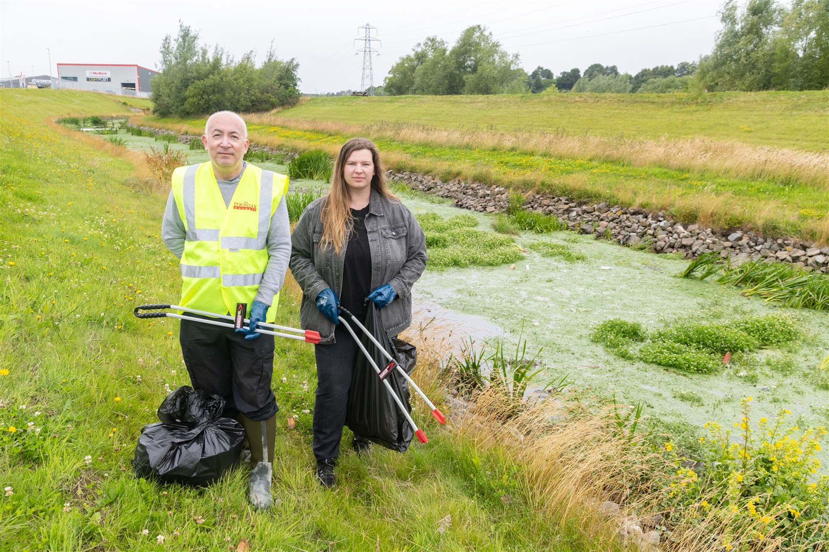 Councillors Marc Macrae (Fochabers/Lhanbryde, Conservatives) and Amber Dunbar (Elgin North, Conservative) litter picking along the flood alleviation beside Grampian Furnishers in Elgin...Picture: Beth Taylor.