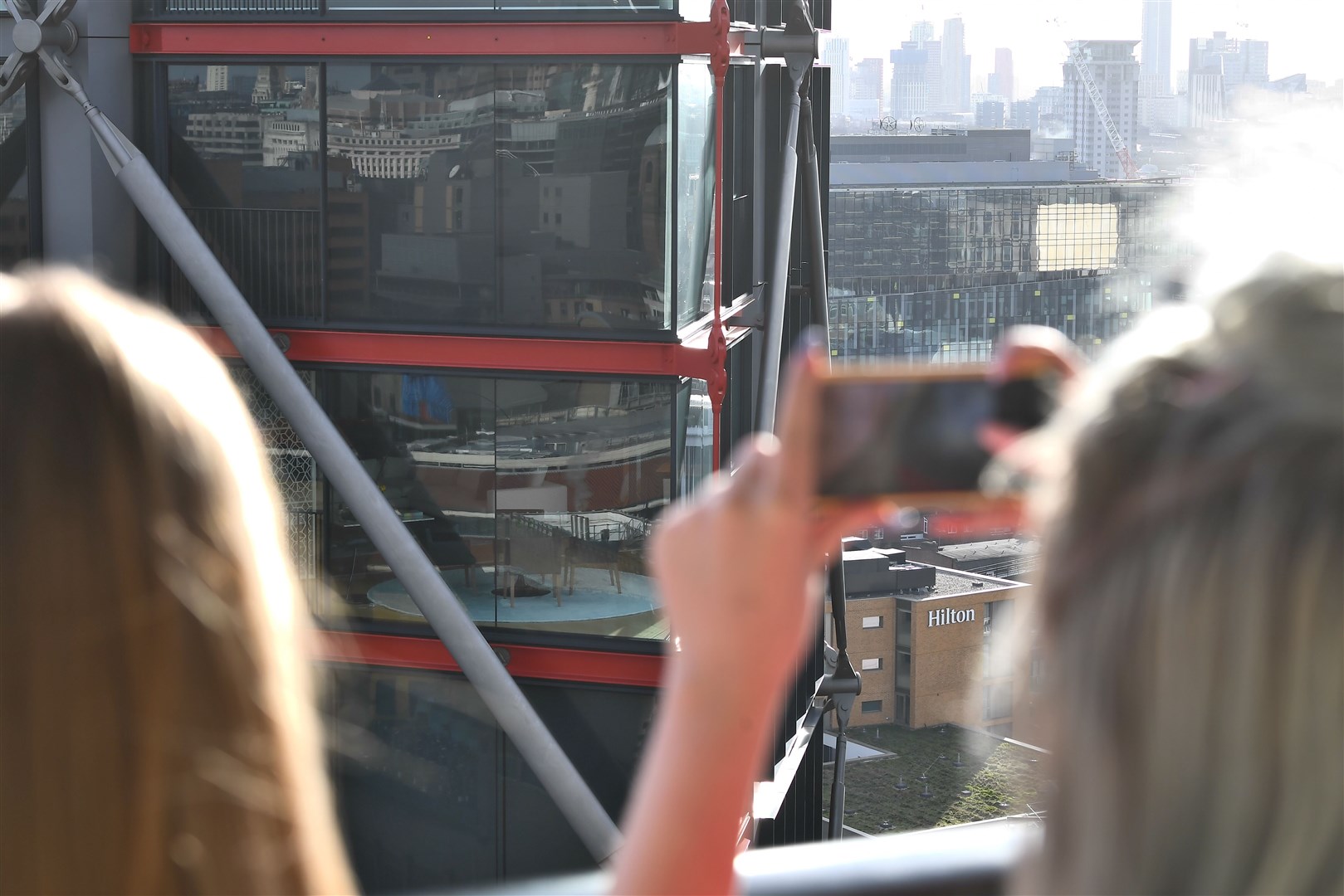 People take pictures from the viewing platform at Tate Modern (left), which overlooks the residential flats (right) (Victoria Jones/PA)