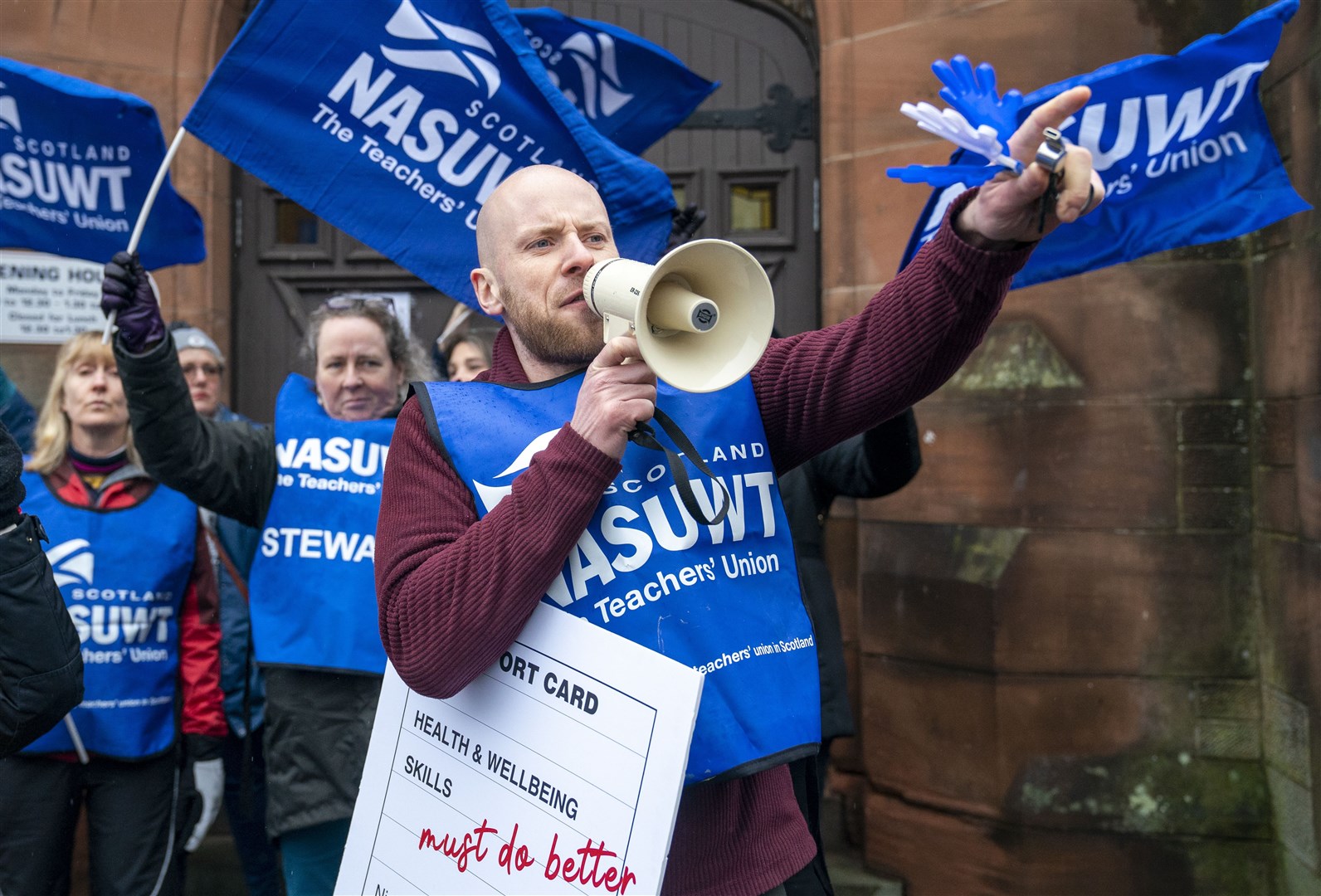 Members of NASUWT the teachers’ union, deliver a ‘report card’ outside the constituency office of First Minister Nicola Sturgeon in Glasgow as teachers walk out amid a pay dispute (Jane Barlow/PA)