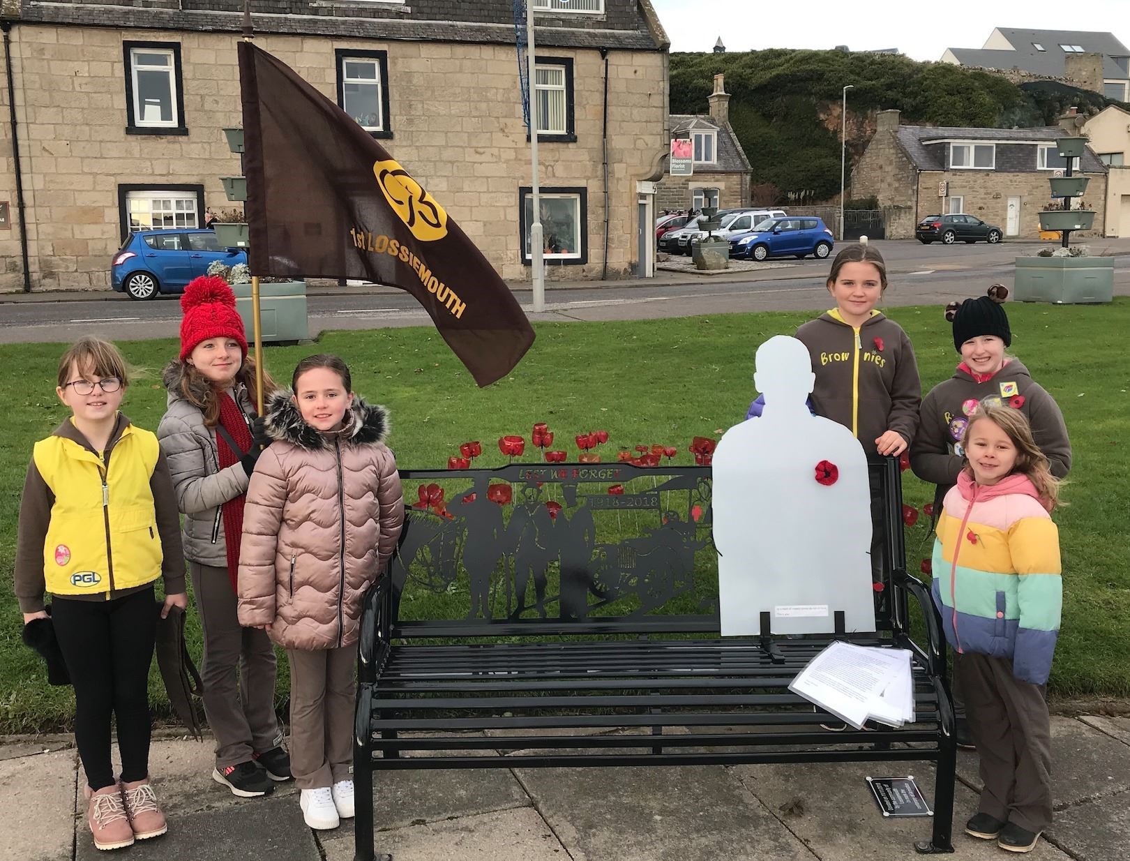 1st Lossiemouth Brownies with a statue of a soldier.