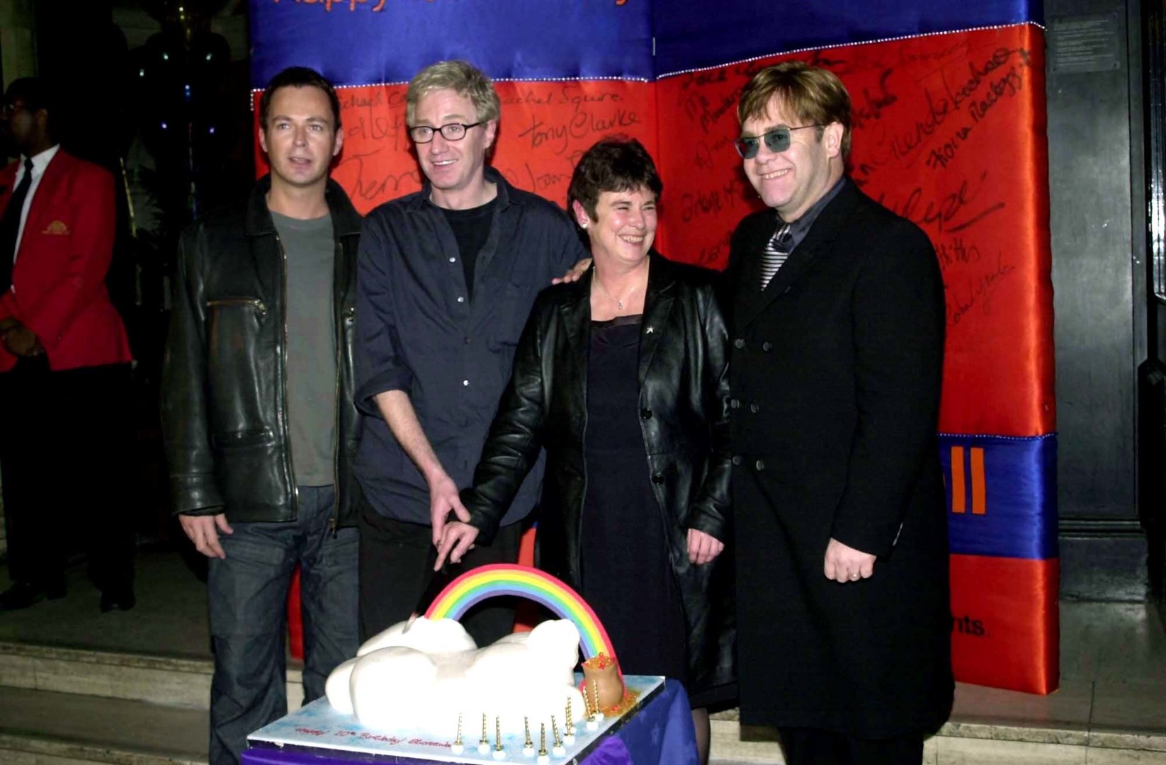 Cutting a cake to mark Stonewall’s 10th birthday with, from left, Julian Clary, Angela Mason and Sir Elton John in 1999 (PA)