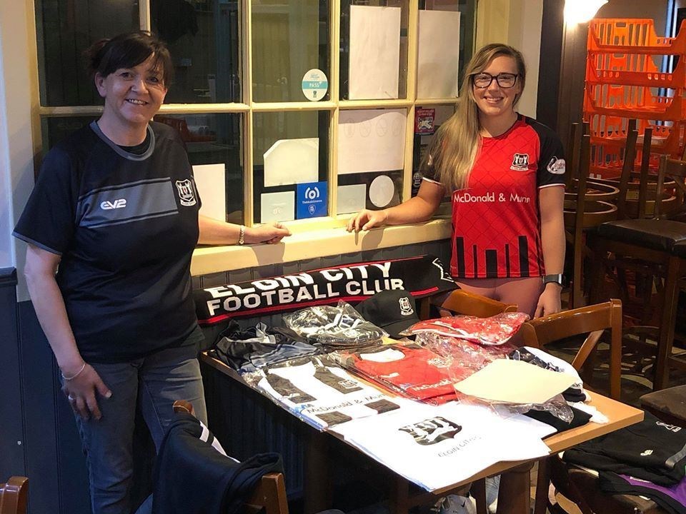 Volunteers Julie Roy (left) and Katie Boynes display some of the Elgin City merchandise donated by the Moray club to the Feldy-Roo project.