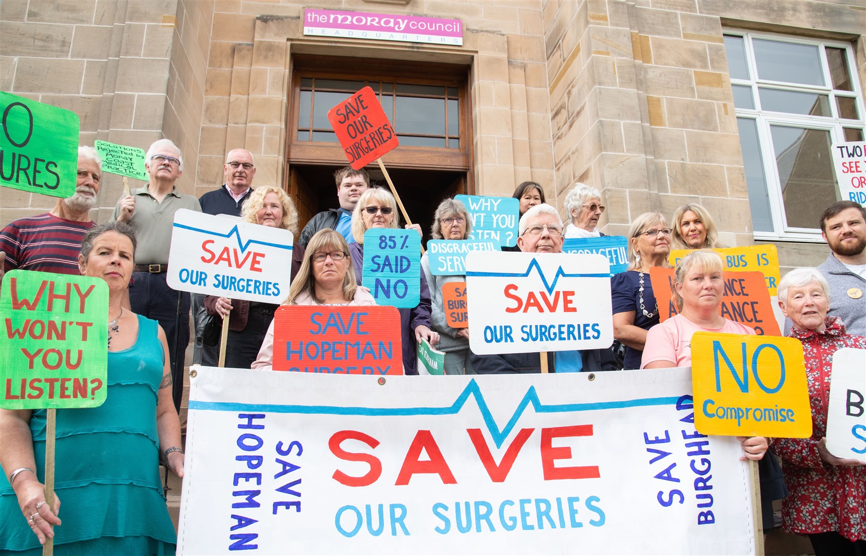 Protesters of the closure of the Burghead and Hopeman Surgeries gathered outside the Moray Council HQ ahead of the Integration Joint Board meeting on July 29th. Picture: Daniel Forsyth